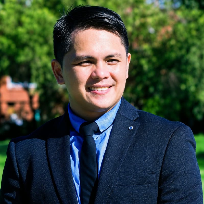 Henry Delfino wearing a navy suit outdoors